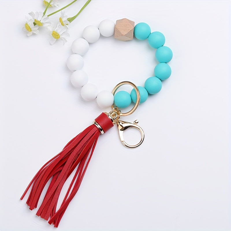 Bracelet with turquoise beads, white beads, a red tassel, and gold clasp on a light blue background.
